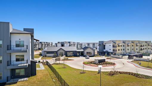 A modern residential area with multiple buildings and a clear blue sky.