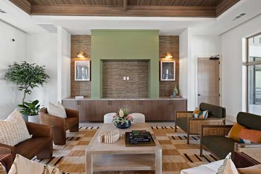 A living room with a brown couch, a coffee table, and a green accent wall.
