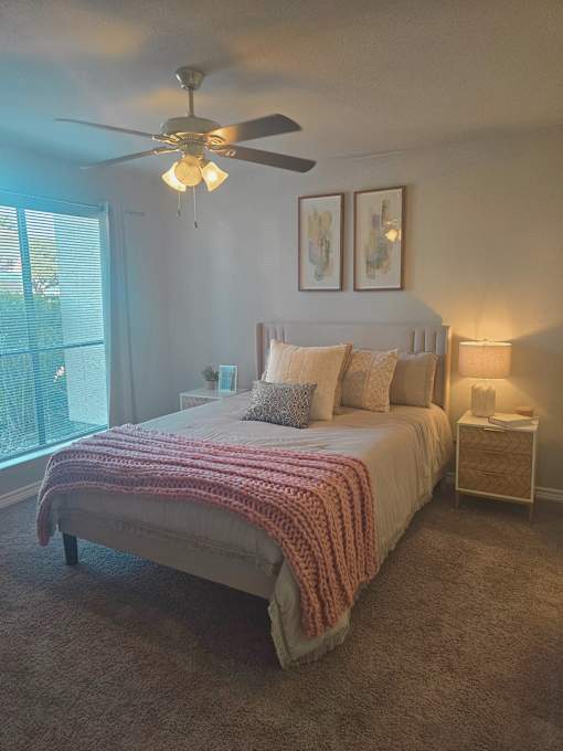 a bedroom with a bed and a ceiling fan
