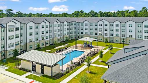 A large apartment complex with a pool in the middle.