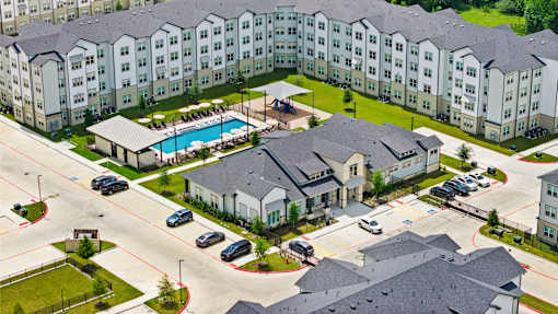A large apartment complex with a pool in the middle.