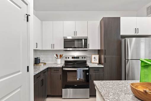 A modern kitchen with a stove top oven and microwave above it.