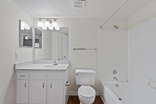 A white bathroom with a sink, toilet, and bathtub.