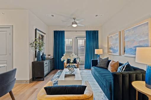 A living room with a dark blue couch and a wooden coffee table.