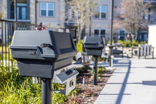 A row of black mailboxes are lined up on the sidewalk. at Enclave on Ross Apartments, Del Valle