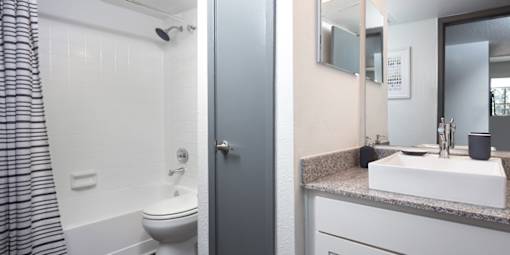 A bathroom with a toilet, sink, and mirror.
