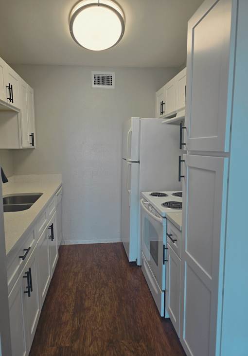 a kitchen with white cabinets and white appliances and a white refrigerator