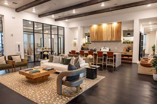 A modern living room with a wooden floor and a large window. at Enclave on Ross Apartments, Del Valle, TX
