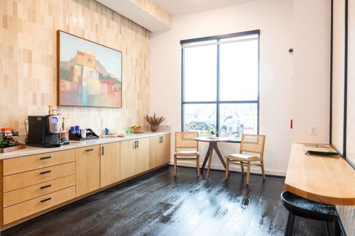A kitchen with wooden cabinets and a painting on the wall. at Enclave on Ross Apartments, Texas, 78617