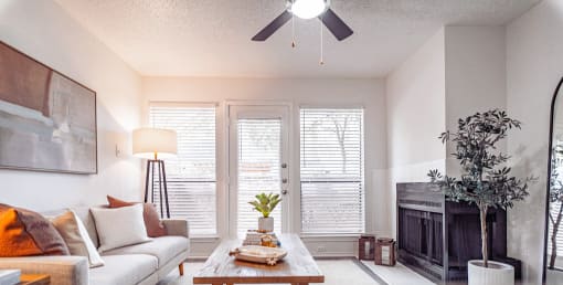 a living room with a couch and a fireplace and a ceiling fan