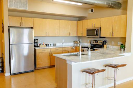 A kitchen with a refrigerator, microwave, and stove.