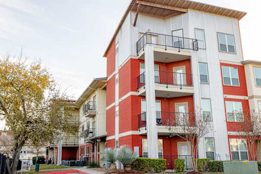 A red and white apartment building with balconies.