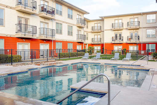 A swimming pool in front of apartment buildings.