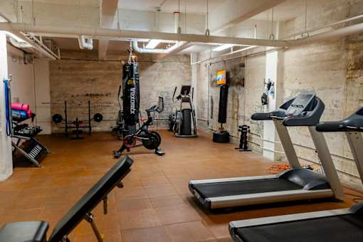 A gym with treadmills, weights, and exercise equipment.
