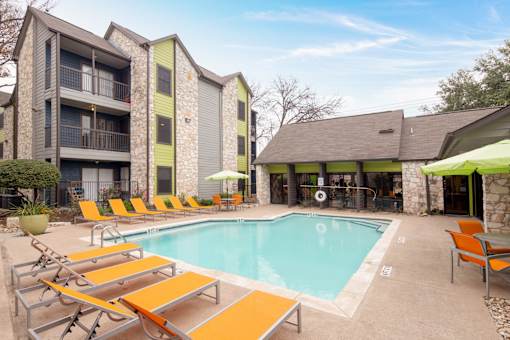 A swimming pool surrounded by orange sun loungers.