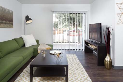 A living room with a green couch and a black coffee table.