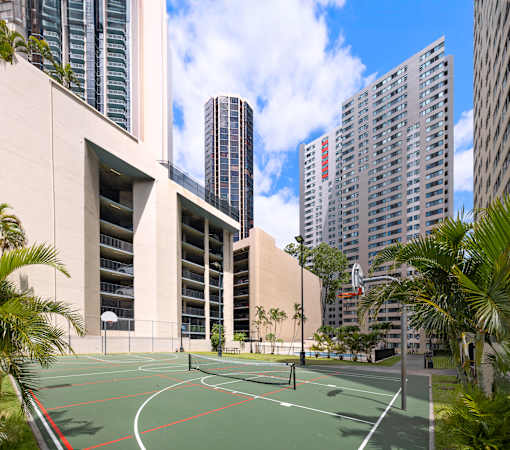 A basketball court is surrounded by tall buildings.