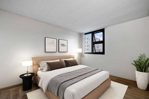 A bedroom with a large bed and a potted plant.