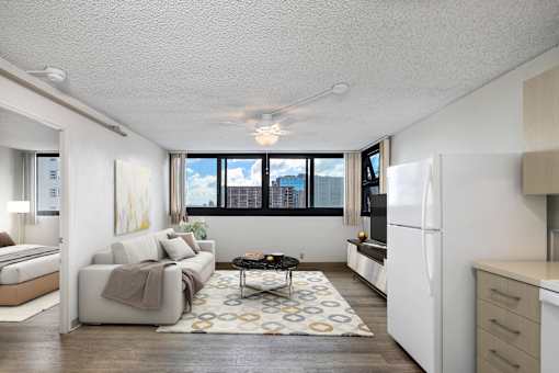 A living room with a couch, a coffee table, and a large window.