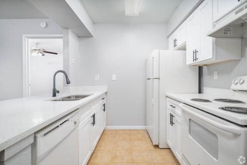 a white kitchen with white appliances and white cabinets