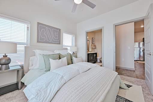 A bedroom with a large bed and a ceiling fan.