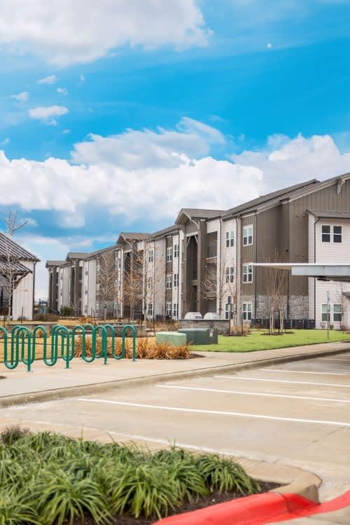 A row of townhouses with a parking lot in front.