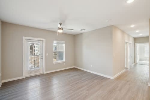 A spacious room with a ceiling fan and sliding glass doors.