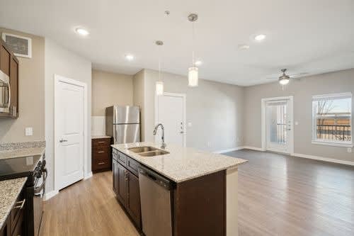 A kitchen with a white countertop and wooden floors.