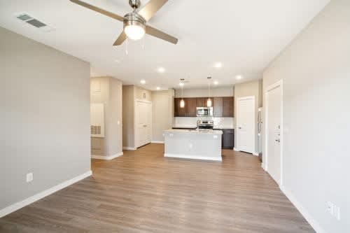 A spacious kitchen with a fan on the ceiling.