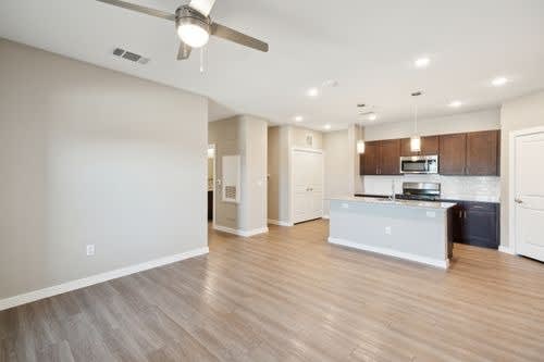 A spacious kitchen with a white countertop and wooden cabinets.
