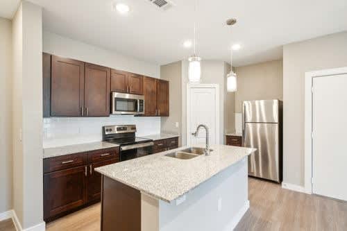 A kitchen with a white countertop and brown cabinets.