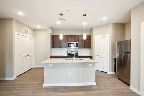 A kitchen with a white island and stainless steel appliances.