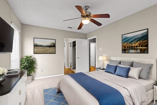 the master bedroom has a large bed and a ceiling fan