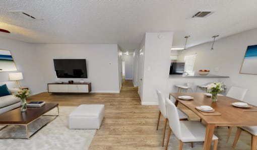 a living room and dining room with a table and chairs and a television
