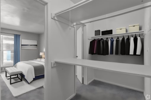 a bedroom with a bed and a closet with a rack of clothes