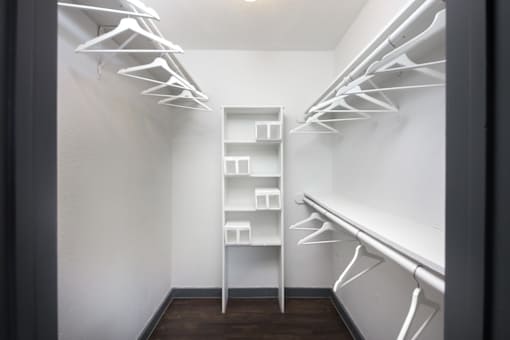 A white closet with a shelf and hangers.