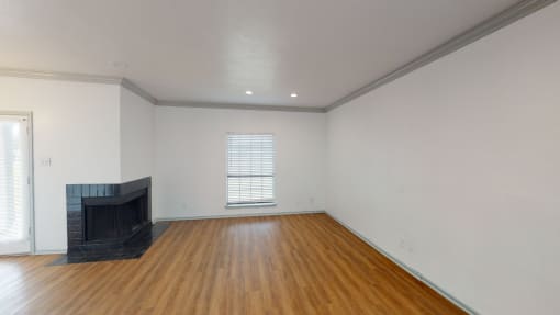 the living room of a home with a fireplace and wooden floors