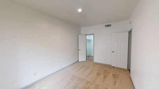 a living room with white walls and a door to a hallway