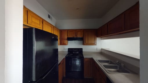 a kitchen with black appliances and wooden cabinets