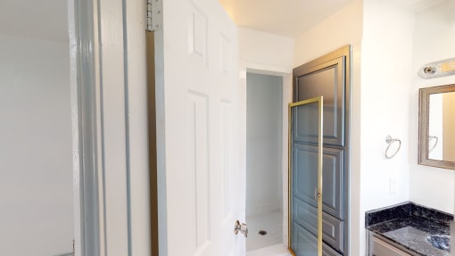 a bathroom with a white door and a sink and a mirror