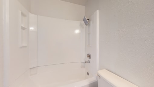 a white bathroom with a shower and a toilet