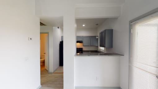 a view of a kitchen and a hallway with a door to a bathroom
