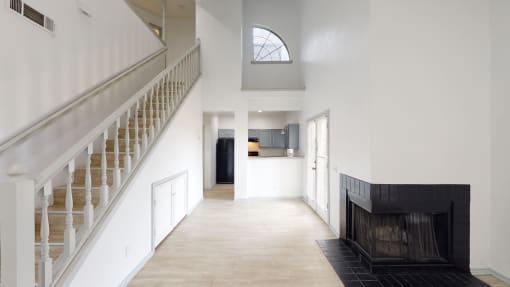 a view of the hallway of a house with stairs and a fireplace