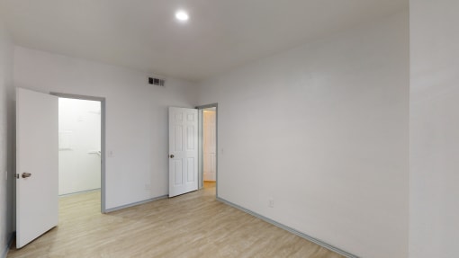 a living room with white walls and a wood floor
