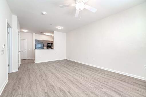A spacious room with a ceiling fan and lighting fixtures.