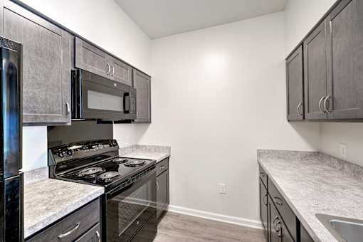 A kitchen with a black stove top oven and microwave.