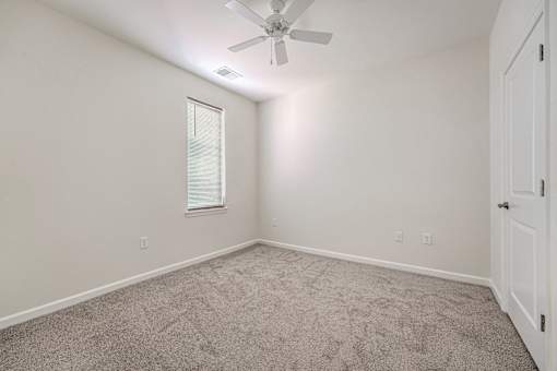 A room with a ceiling fan and a window.