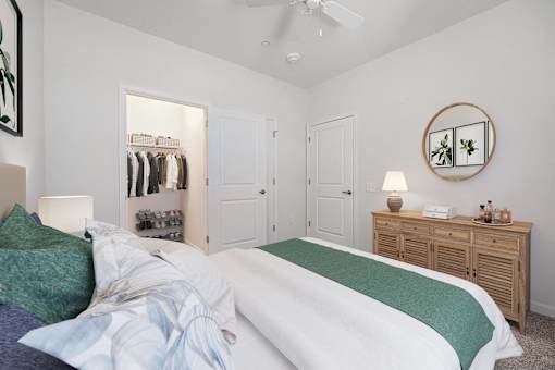 A bedroom with a bed, a dresser, and a mirror.