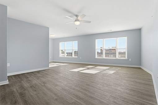 A room with a ceiling fan and a large window.