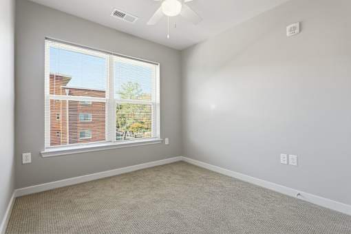 A room with a window and a ceiling fan.